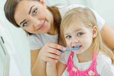 Mom and Daughter brushing their teeth - Pediatric Dentist in Littleton, CO